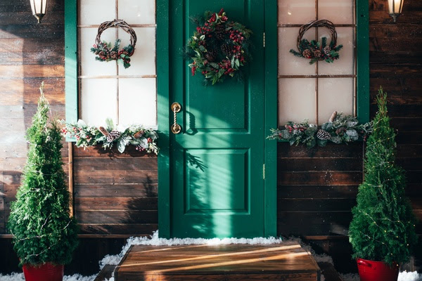 Porch with wooden doors and a threshold with Christmas decor. New year home decoration.