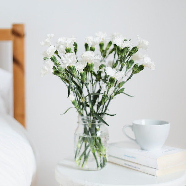 Bouquet of white flowers in a white bedroom